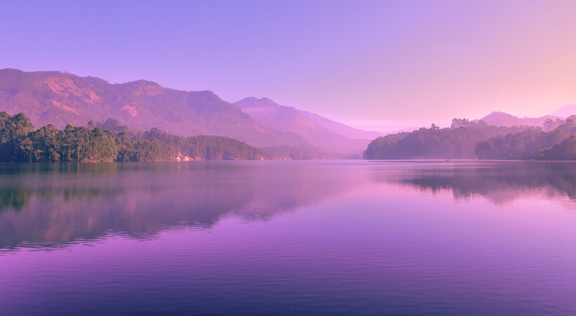 Wunderschöner See mit Bergen im Hintergrund in blau-lila Farben